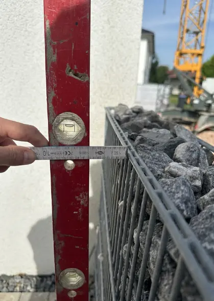 Typisches Schadensbild infolge von Geländesetzungen: Verkippungen von Gabionen und Gartenmauern.